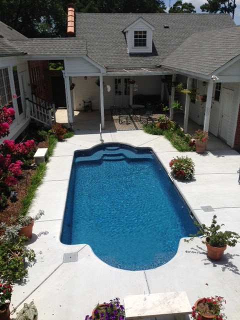 A freeform swimming pool installed in a residential courtyard by Central Pools, Inc. in Baton Rouge, LA.