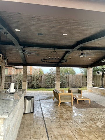 A covered patio with modern recessed lighting and ceiling fan installations completed by LOJ Electric, LLC in Houston, TX.