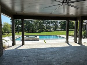 A view of a rectangular swimming pool and spa from a covered patio by Top Tier Pools in Franklin, TN.