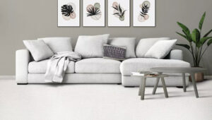 A cozy living room featuring a large white sectional sofa and a freshly installed light-colored carpet by Floors By Tomorrow in Aurora, CO