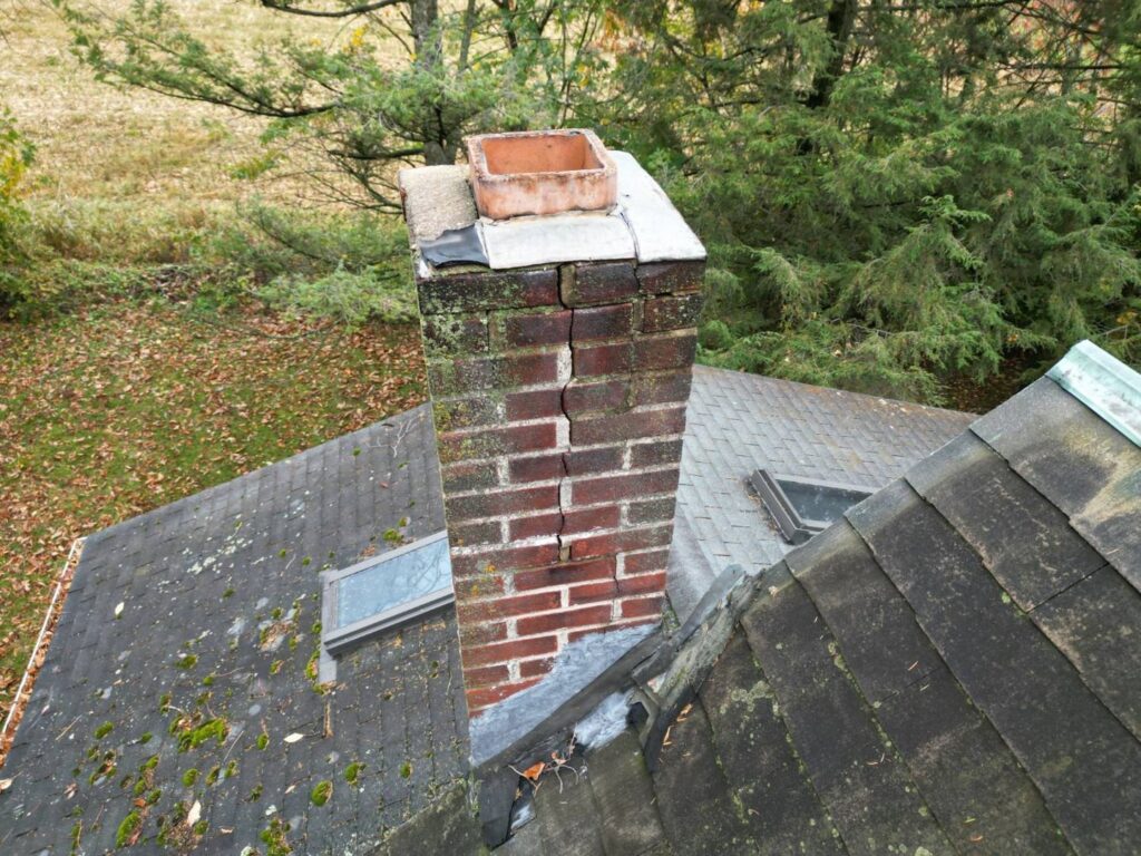 A brick chimney showing a significant vertical crack, indicating a need for repair by Maximum Energy Savers in Philadelphia, PA