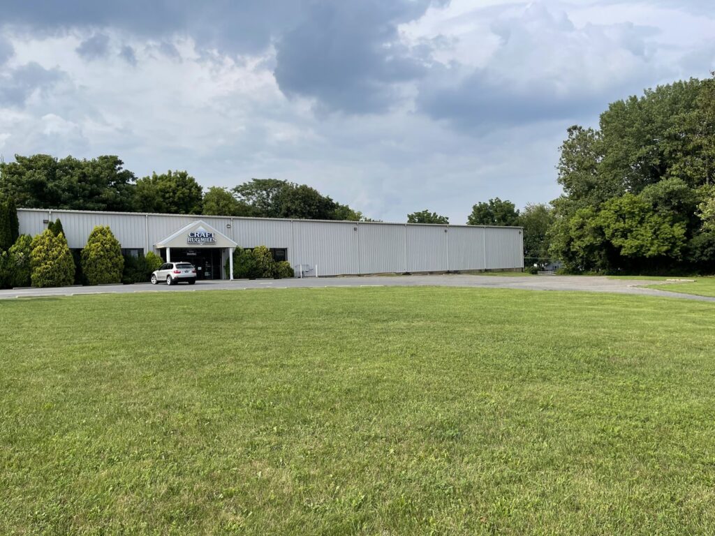 A wide exterior view of the Craft Rug Mills building with a large lawn in Easton, PA.