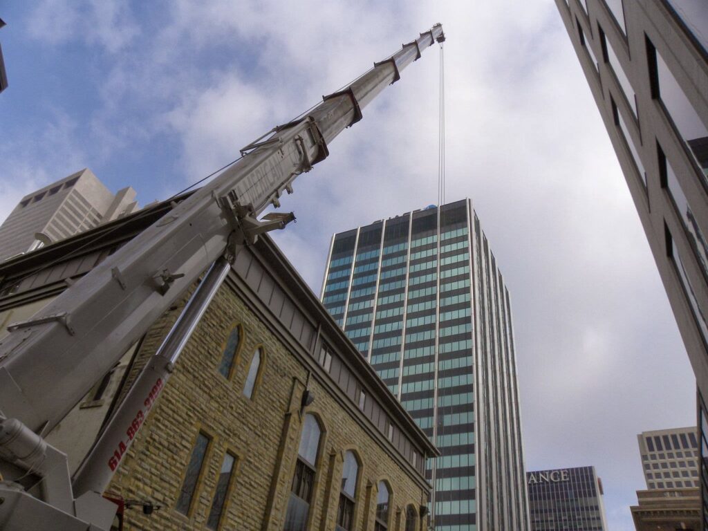 A large crane positioned for a rooftop HVAC installation project by AireCom HVAC in Columbus, OH.