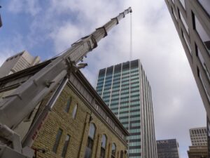 A large crane positioned for a rooftop HVAC installation project by AireCom HVAC in Columbus, OH.