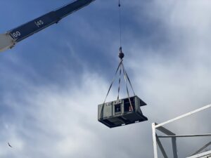 A crane lifting a large commercial HVAC unit during installation by Vanessa Service HVAC in Falls Church, VA.