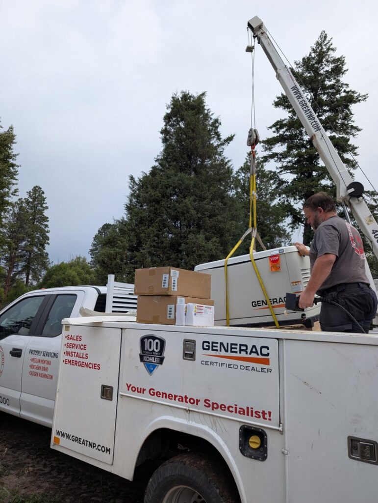 A crane lifting a Generac generator from a Great Northern Power truck during installation in Kalispell, MT.