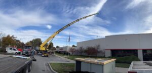 A large crane lifting new HVAC equipment for installation on a commercial building by DMC Service, Inc. in Olathe, KS.
