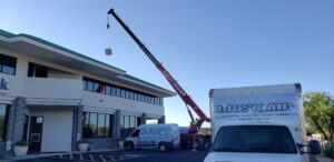A crane lifting an HVAC unit onto a commercial building during an installation by Brisk Air Inc in Phoenix, AZ.