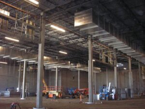 A crane lifting a large commercial HVAC unit onto a building for installation by American Mechanical Corp in Caldwell, ID