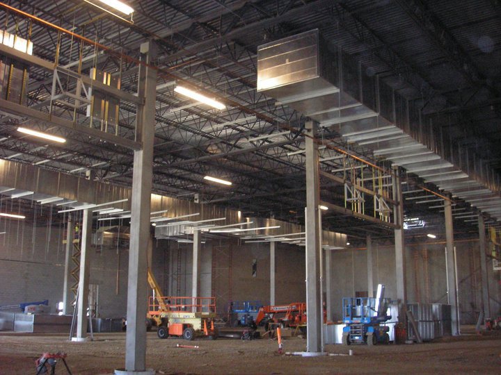 A crane lifting a large commercial HVAC unit onto a building for installation by American Mechanical Corp in Caldwell, ID
