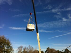 A crane lifting an HVAC unit into place during an installation project by R&B Cooling&Heating in Abbeville, LA.