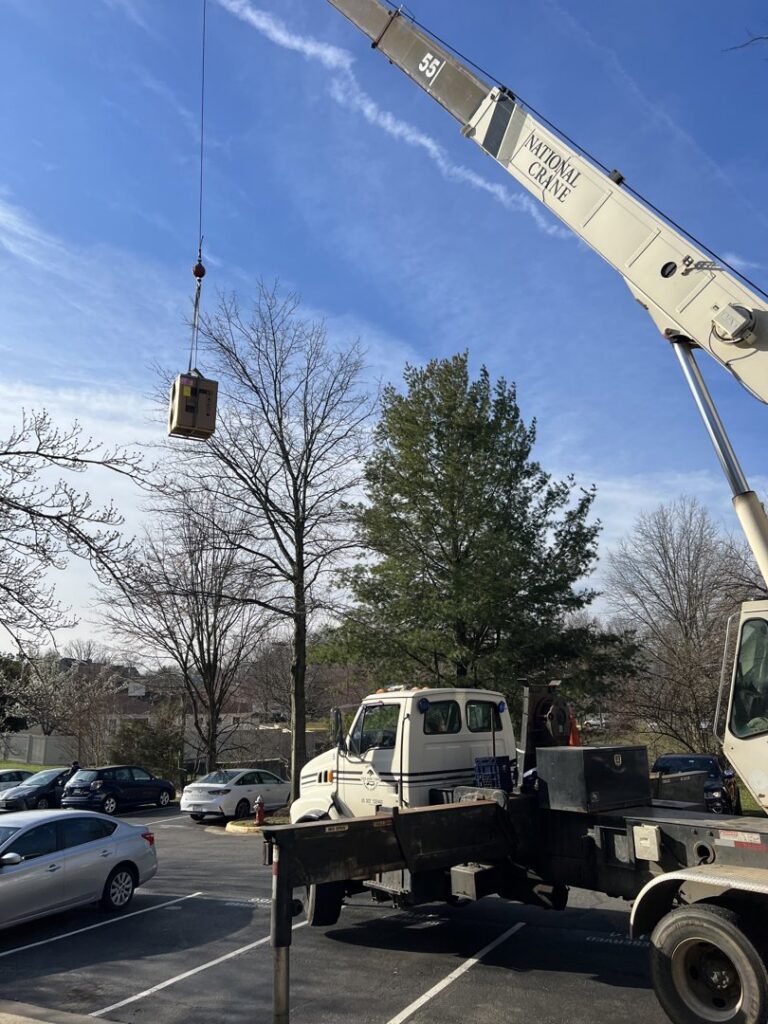 A crane lifting an HVAC unit during a commercial installation by Rescue Heating and Air Conditioning in Manassas, VA
