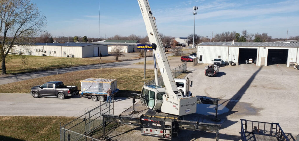 A crane lifting a large HVAC unit for installation by Tornado Heating and Air in Tulsa, OK.