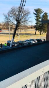 A crane lifting an HVAC unit onto a commercial rooftop for installation by American Air LLC in Moncks Corner, SC