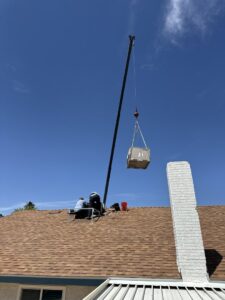 A crane lifting an HVAC unit onto a residential roof for Rebel Refrigeration in Las Vegas, NV.