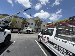 A crane lifting an HVAC unit onto a rooftop during an installation by AC Heating and Air Conditioning Services in Charleston, SC.