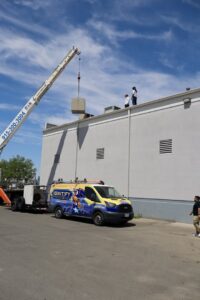 A crane lifting an HVAC unit onto a commercial rooftop for installation by Ignitify Commercial Grade HVAC in El Paso, TX.