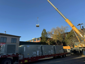 A crane lifting new HVAC units for installation by Air Masters HVAC Services of New England, Inc. in Fall River, MA.