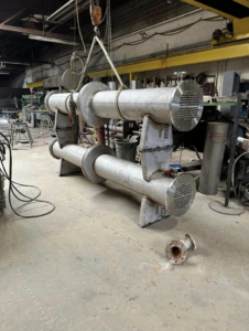 Crane lifting industrial heat exchangers at Capital City Boiler & Machine Works, Inc. in Des Moines, IA