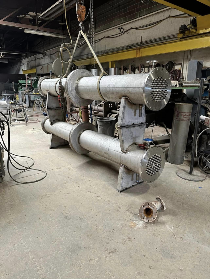 Crane lifting industrial heat exchangers at Capital City Boiler & Machine Works, Inc. in Des Moines, IA