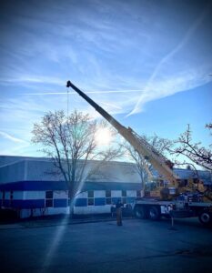 A crane lifting large HVAC equipment during an installation project by Cafco Services in Cincinnati, OH.