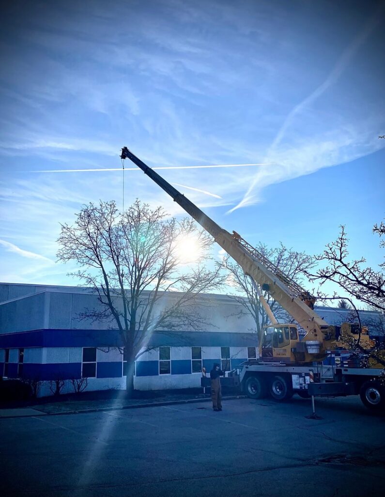 A crane lifting large HVAC equipment during an installation project by Cafco Services in Cincinnati, OH.