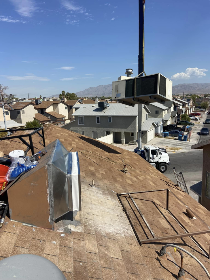 A crane lifting a new HVAC unit onto a residential rooftop for installation by Aire & Air Heating and Cooling LLC in Las Vegas, NV.