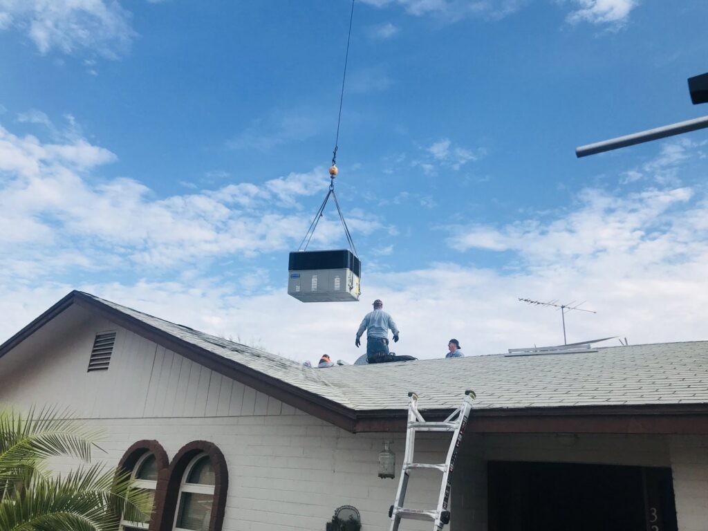 A crane lifting a new HVAC unit onto a residential roof for installation by All Metro Air Conditioning in Apache Junction, AZ.