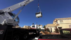 A crane lifting a residential HVAC unit during an installation or replacement by Blue Collar HVAC in Las Vegas, NV.