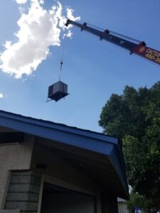 A crane lifting a new rooftop HVAC unit for installation by A+ Air and Aeroseal in Scottsdale, AZ.