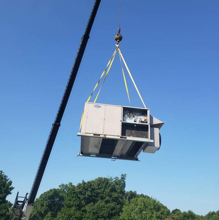 A crane lifting a large rooftop HVAC unit for installation by Air Energy Solutions in North Chesterfield, VA