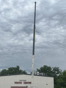 A crane lifting a large rooftop HVAC unit during an installation project by Dowd Heat & Air in Tulsa, OK.