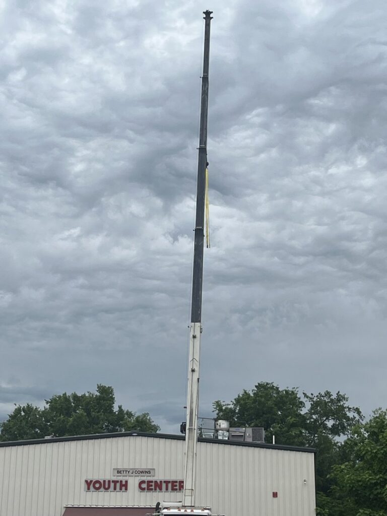 A crane lifting a large rooftop HVAC unit during an installation project by Dowd Heat & Air in Tulsa, OK.