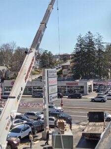 A crane lifting a new rooftop HVAC unit into place for Enviromax Heating & Cooling in Peekskill, NY.