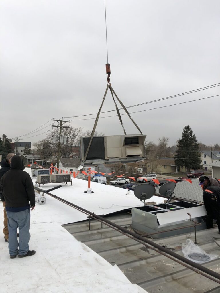 A crane lifting a new commercial rooftop HVAC unit during installation by 5280 Cooling Heating & Refrigeration in Lakewood, CO