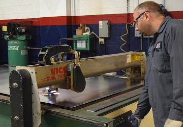 A crane lifting a large commercial HVAC unit onto a rooftop for installation by Saucier Mechanical Services in Plantsville, CT.