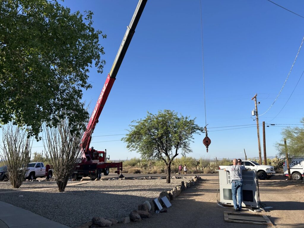 A crane preparing to lift a new HVAC unit from the ground for installation by Ash Cooling & Heating in Mesa, AZ.