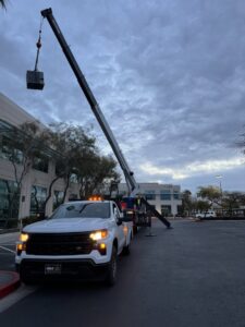 A crane truck lifting an HVAC component at a commercial building for Rogue Mechanical in Las Vegas, NV.