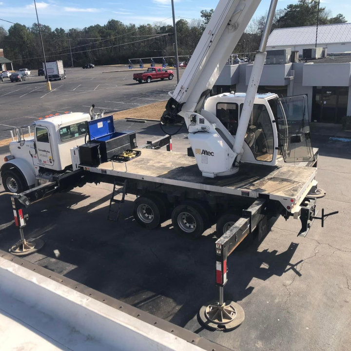 A large crane truck positioned on a commercial rooftop, ready for heavy HVAC equipment installation or removal by Eleven Heating and Cooling in Birmingham, AL.