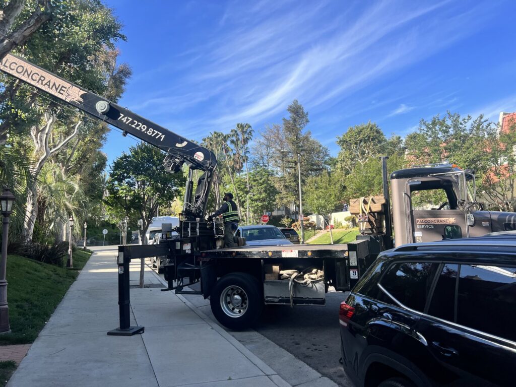 A crane truck on a residential street, ready for an HVAC installation project by MB Heating and Air in Northridge, CA.