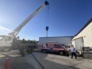 A crane truck and Rebel Refrigeration van on site for an HVAC installation in Las Vegas, NV.