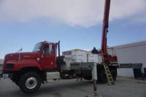 A crane truck loaded with new HVAC units, ready for installation by Air Quality, LLC in Cranston, RI
