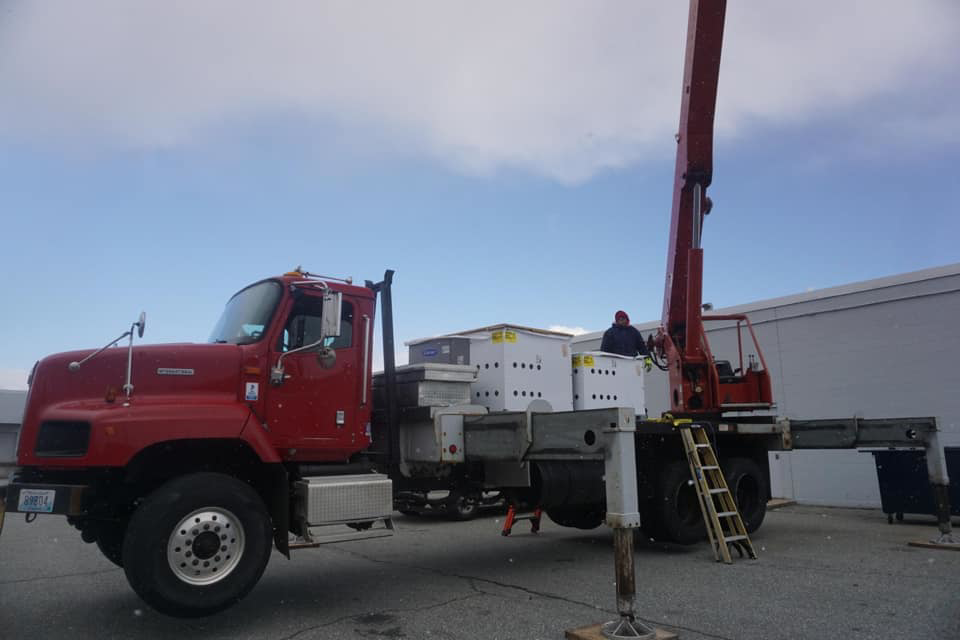 A crane truck loaded with new HVAC units, ready for installation by Air Quality, LLC in Cranston, RI