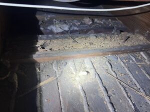 Close-up of debris and damaged wood in a crawl space needing removal by Taff Service Company LLC in Columbus, GA.