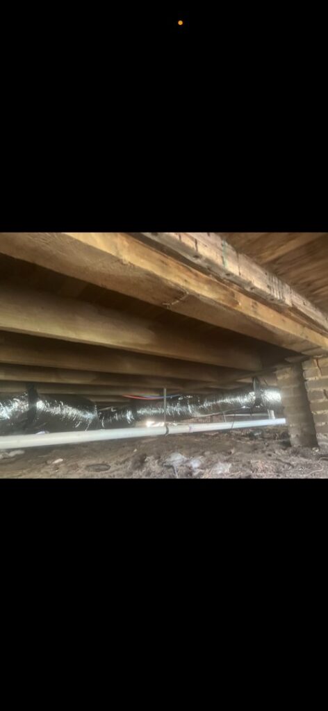 Insulated HVAC ductwork visible in a crawlspace under a house, installed by Budget Heating and Air in Mobile, AL.