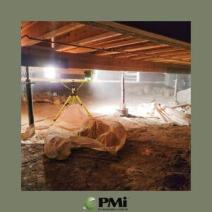 An illuminated crawl space under a house during an inspection by Pest Management Systems, Inc. in Greensboro, NC