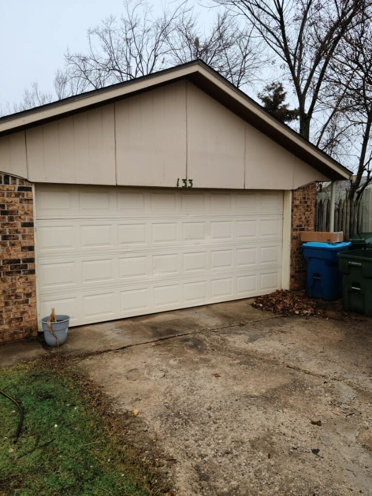 A cream residential garage door installed on a brick house by Entry Garage Door in Shawnee, OK.