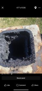 A close-up view of heavy creosote buildup inside a chimney flue, indicating a need for chimney sweeping by Harry's Quality Chimney Services in Kansas City, MO