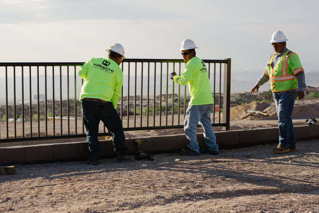 A crew from Hirschi Iron installing a black metal fence or railing on a property in North Las Vegas, NV.