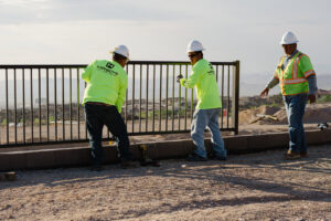 A crew from Hirschi Iron installing a black metal fence or railing on a property in North Las Vegas, NV.